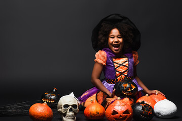Fototapeta premium Little girl shines in vibrant Halloween costume amidst festive decorations