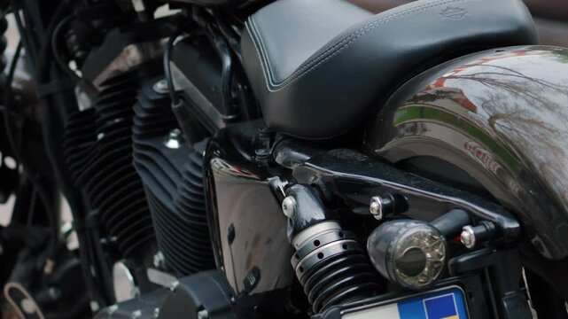 Close up shot of black motorcycle side body engine seat and rear wheel parts.