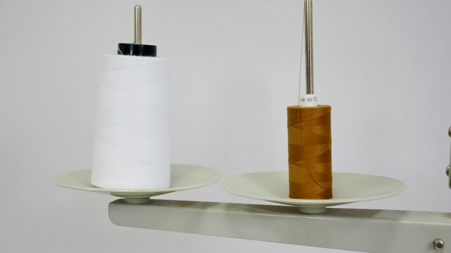 Industrial sewing machine thread spools on holder.