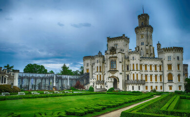 Professional architecture photography of Hluboka nad Vltavou castle front view with formal park. Famous romantic landmark building under storm sky for travel guide catalog. © Jan