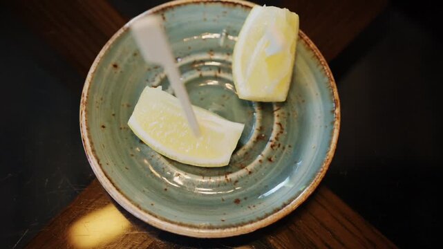 Fresh lemon slices served on small ceramic plate close up.