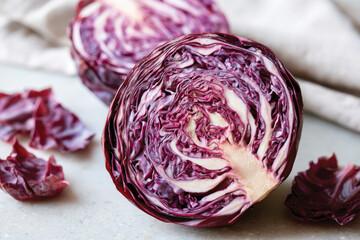 Fototapeta premium This image features a sliced purple cabbage revealing its unique, intricately folded leaves, perfect for salads or as a vibrant decoration in food presentations.