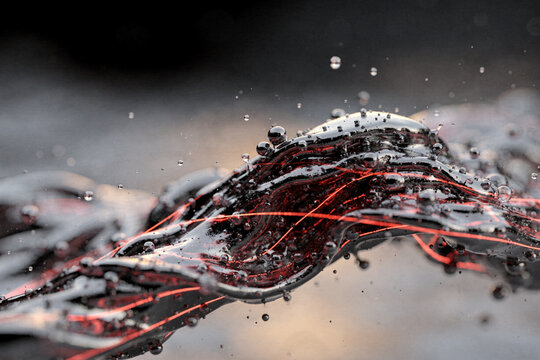 Abstract macro shot of glossy black liquid wave with glowing red neon fibers and floating droplets in dynamic motion