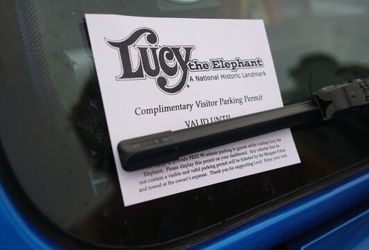 Margate City, New Jersey, U.S.A - Aug 16, 2026 - ucy the Elephant complimentary parking permit offering 90-minute visitor parking with towing warning for vehicles without visible permits.