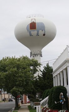 Margate City, New Jersey, U.S.A - Aug 16, 2026 - Decorated Lucy The Elephant water tower overlooking Benson Street homes with garden decor and neighborhood landscaping.