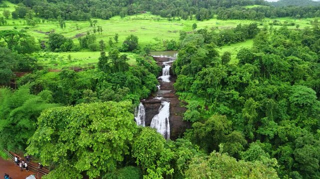 Aerial View Revealing Ashoka Waterfall Near Nashik, Maharashtra, India, Gradually Uncovering Cascading Monsoon Water Surrounded by Lush Green Forest, Rocky Terrain and Scenic Western Ghats Landscape