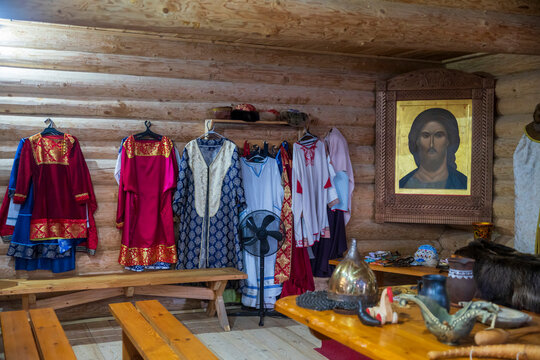 Vologda Oblast, Russia, Ethnographic Complex "Zastava of the Belozersky Princes",Interior room with traditional Russian costumes on hangers, Orthodox icon of Christ in carved wooden frame,   