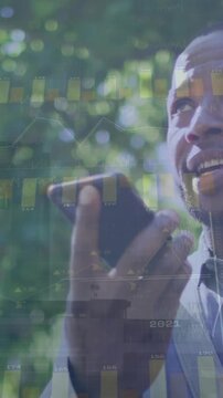Animation of diagrams and data processing over african american businessman talking on smartphone