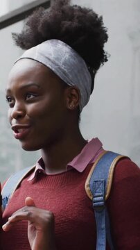 Animation of network of connections with icons over african american woman talking on smartphone