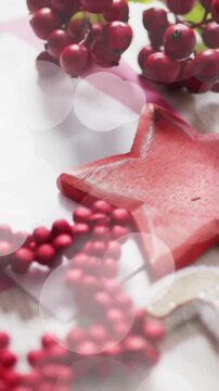 Christmas decorations with red star and berries over bokeh lights animation