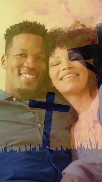 Couple sitting on couch with cross and sunset animation over them