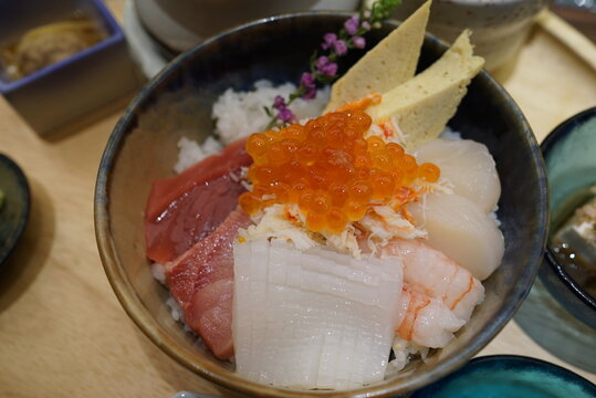 Fresh mixed sashimi rice bowl, Chirashidon or Kaisendon with ikura, tuna, scallop and squid in ceramic bowl