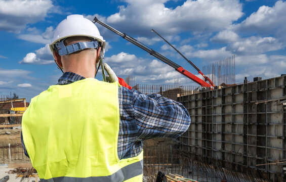 Construction worker monitors project at a site on a sunny day