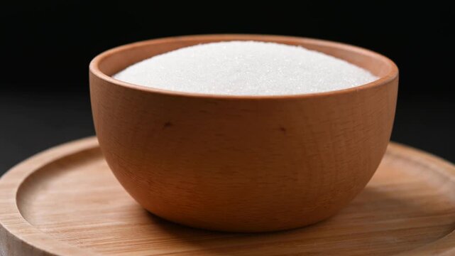 Wooden bowl of white sugar. Close up