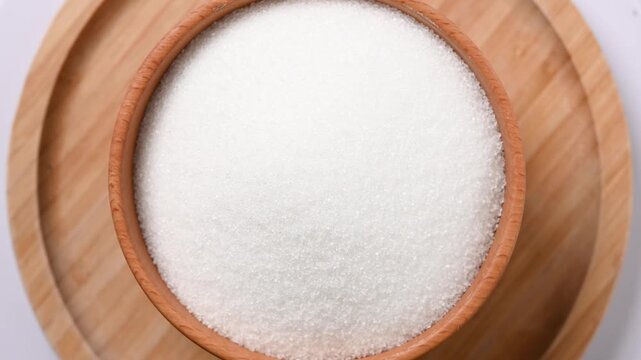 Wooden bowl of white sugar. Close up