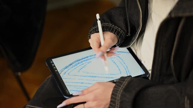 Graphic artist drawing sketch on tablet with digital pencil close up.
