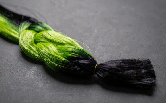 Green and Black Synthetic Braided Hair Extension on Dark Background