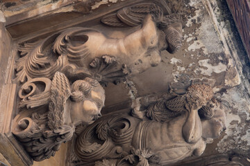 Modica, Italy  1st August 2026: Baroque architectural detail with carved grotesque face and ornate stonework on a balcony in Sicily. © Leckerstudio