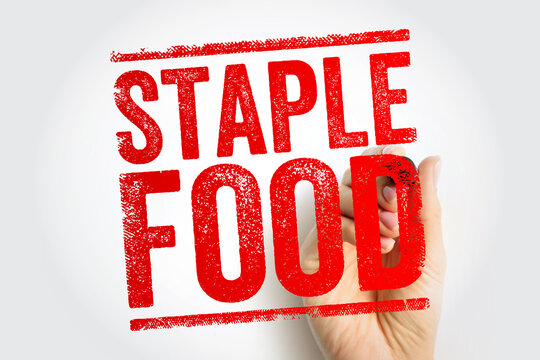 STAPLE FOOD displayed in bold stamp lettering as a hand completes the mark, emphasizing essential nutrition and everyday diet themes suitable for culinary, grocery, health, and lifestyle concepts