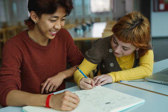 Happy young people study together inside library classroom - University, multiracial students and back to school concept