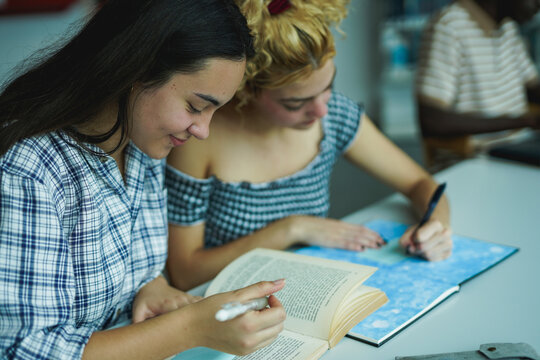 Multiracial students learning together inside school library - Back to school, university and young people concept