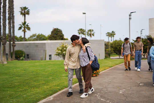 Diverse students walking outside of university - Back to school, education and young people concept - Focus on couple kissing each other