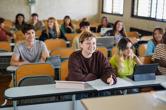 Happy group of multiracial university students having fun together iniside classroom - Back to school, education and diverse young people concept