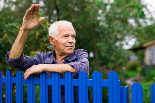 Senior man waving with hand outdoors
