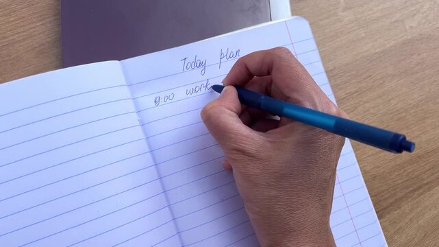 Point of view shot of hand writing in notebook, creative process, daily task.