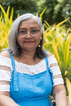 Senior woman with grey hair wearing glasses outdoors