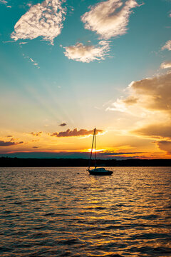 landscape of a peaceful sunset over W&ouml;rthsee lake, near Ammersee in Bavaria, Germany, Europe. Dramatics clouds, Dark, heavy storm clouds gather. Radiant golden sunbeams burst through in the cloud