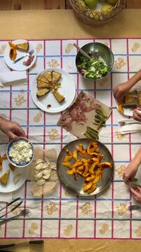 Vertical top view video of father and children serving food at the family table