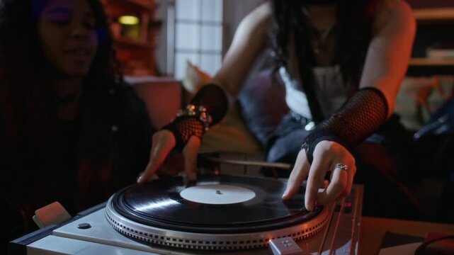 Multiethnic young women changing vinyl record on turntable and dancing at home party. Footage is perfect for music streaming services, audio equipment ads, or youth lifestyle marketing