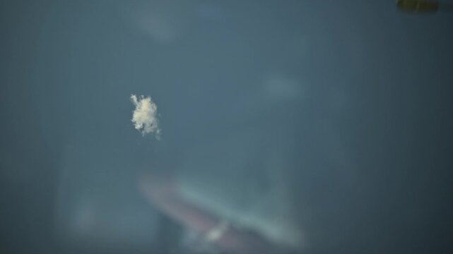 A small cloud in the blue sky as seen through the sunroof of a car