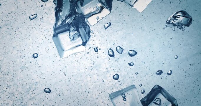 Ice cubes splashing in sparkling water, abstract cold background.
