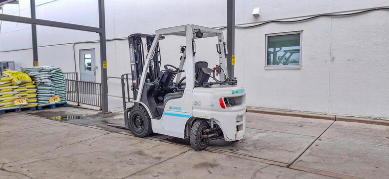 CALGARY, ALBERTA, CANADA - 12 AUGUST 2026: White Industrial UniCarriers Forklift Parked Outside Real Canadian Superstore.