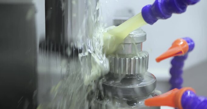 Industrial coolant spraying on CNC metal machining process.