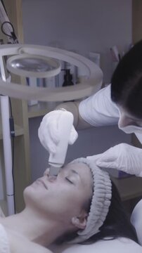 Gentle facial device gliding across relaxed skin under soft light
