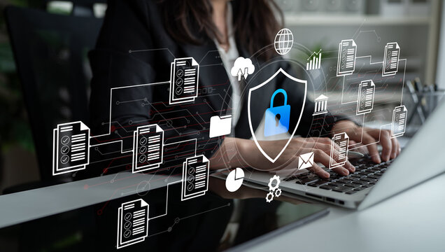 A professional woman engages with her laptop amidst a backdrop of digital security concepts, showcasing the importance of data protection in today technology-driven world. Ledger