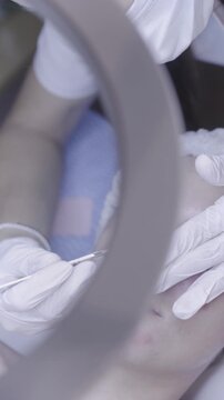 Gloved fingers smoothing product along closed eyelid in gentle facial care