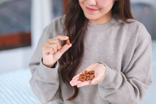 Closeup image of hands holding and picking up an almonds