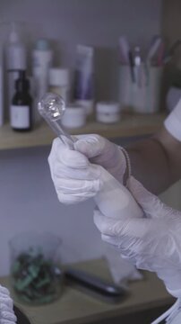 Gloved hand directs slender applicator toward the eye in careful skincare routine