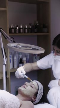 Practitioner sweeps cotton swab gently across skin in calming facial routine