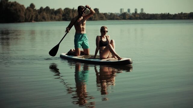 Paddlers Riding Stand Up Paddleboard On Calm River Surface 