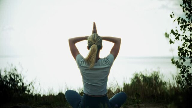 Yogi Practicing Yoga Lotus Pose With Raised Hands Near Water Surface 