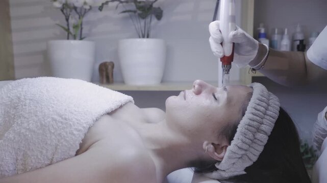Illuminated wand hovering above the nose in a serene facial ritual