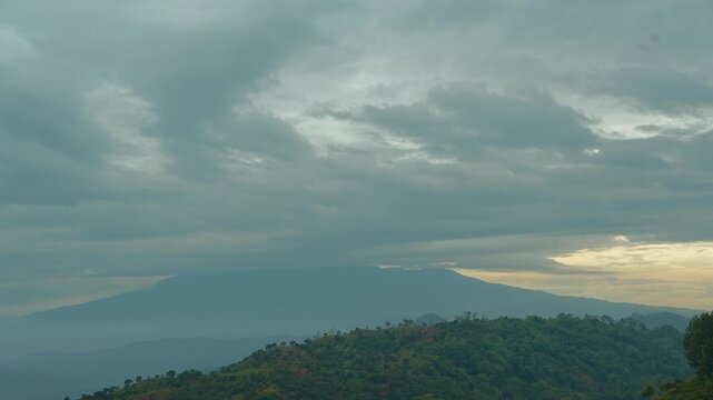 Timelapse Cloud Movement Over Mount Ciremai at Sunrise with Misty Mountain Range and Forest Hills