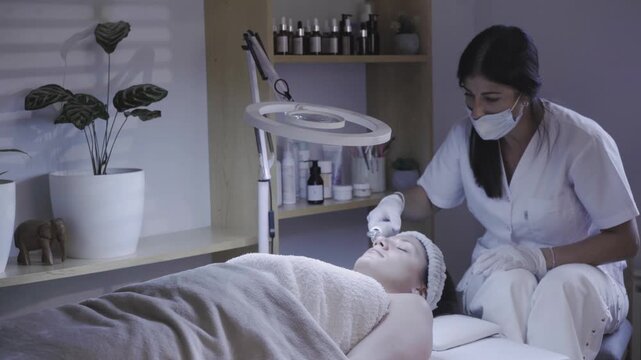 Focused esthetician cleansing the face during a gentle skincare session