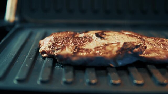 Juicy Beef Steak Cooking On Electric Grill 