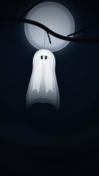 Fabric ghost decoration sways eerily from a tree branch in pale moonlight